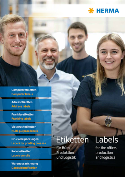 Vier Personen in Arbeitskleidung stehen lächelnd zusammen, umgeben von Etikettenprodukten und Dienstleistungen von HERMA.