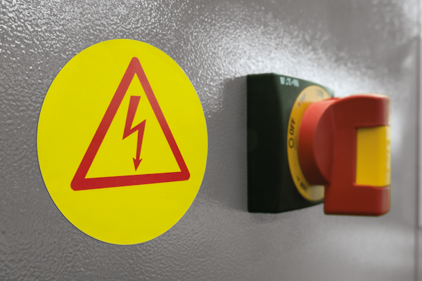 Gelbes rundes Warnschild auf Elektroanlage
