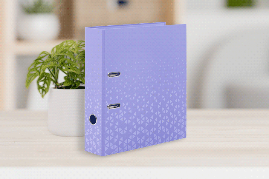 Lila Color Ordner von HERMA mit geometrischem Muster, auf einem Tisch neben einer kleinen Pflanze.