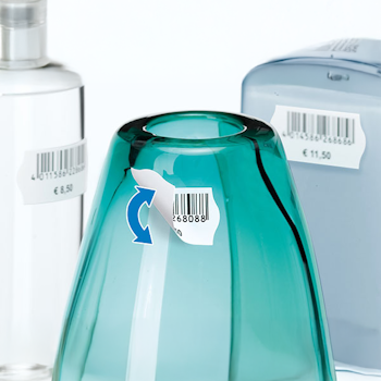 Ein türkisfarbener Glasbehälter mit einem Preisschild, umgeben von anderen Flaschen und Behältern.