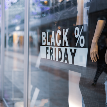 Schaufenster mit der Aufschrift "BLACK FRIDAY" von HERMA und einem das Kleidung präsentiert.
