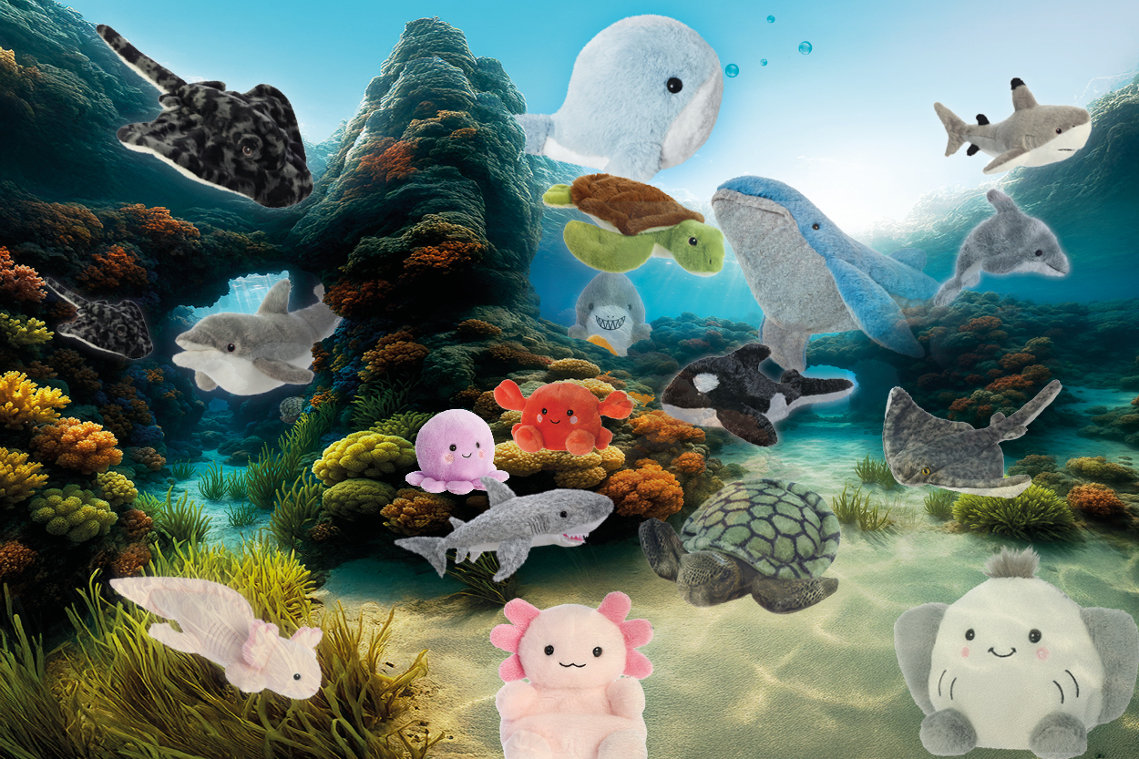 Plüschtiere verschiedener Meereslebewesen, darunter Wale, Haie, Schildkröten und Seesterne, in einer bunten Unterwasserlandschaft.