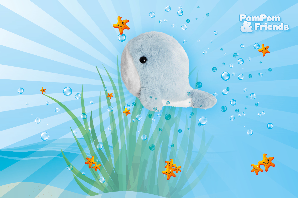 Ein blauer Plüschwal schwimmt unter Wasser, umgeben von Wasserblasen und orangefarbenen Seesternen, mit grünem Seegras im Hintergrund.