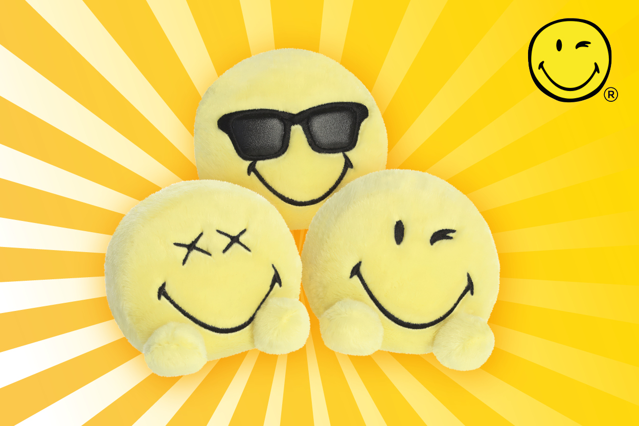 Drei gelbe Smiley-Kissen mit unterschiedlichen Gesichtsausdrücken: einer mit Sonnenbrille, einer mit X-Augen und einer mit einem breiten Lächeln.
