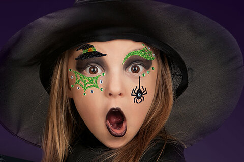 Mädchen das mit Face Art Stickern als Hexe verkleidet ist
