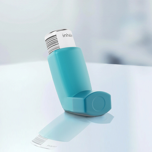 Ein blauer Asthmaspray-Inhalator steht auf einer reflektierenden Oberfläche.