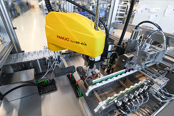 Industrieroboter von FANUC, Modell R-6iA, in einer automatisierten Fertigungsumgebung, mit verschiedenen Komponenten zur Montage.