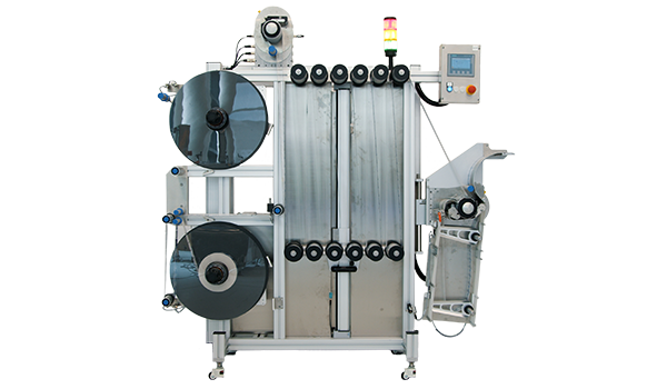 Eine industrielle Verpackungsmaschine mit zwei großen Rollen, Steuerungseinheit und einem Ausgabebereich für verpackte Produkte.