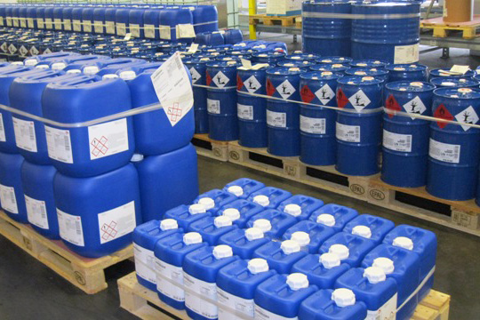 GHS-Etikettten und Chemie-Etiketten auf blauen Kunststoffkanistern, auf Paletten