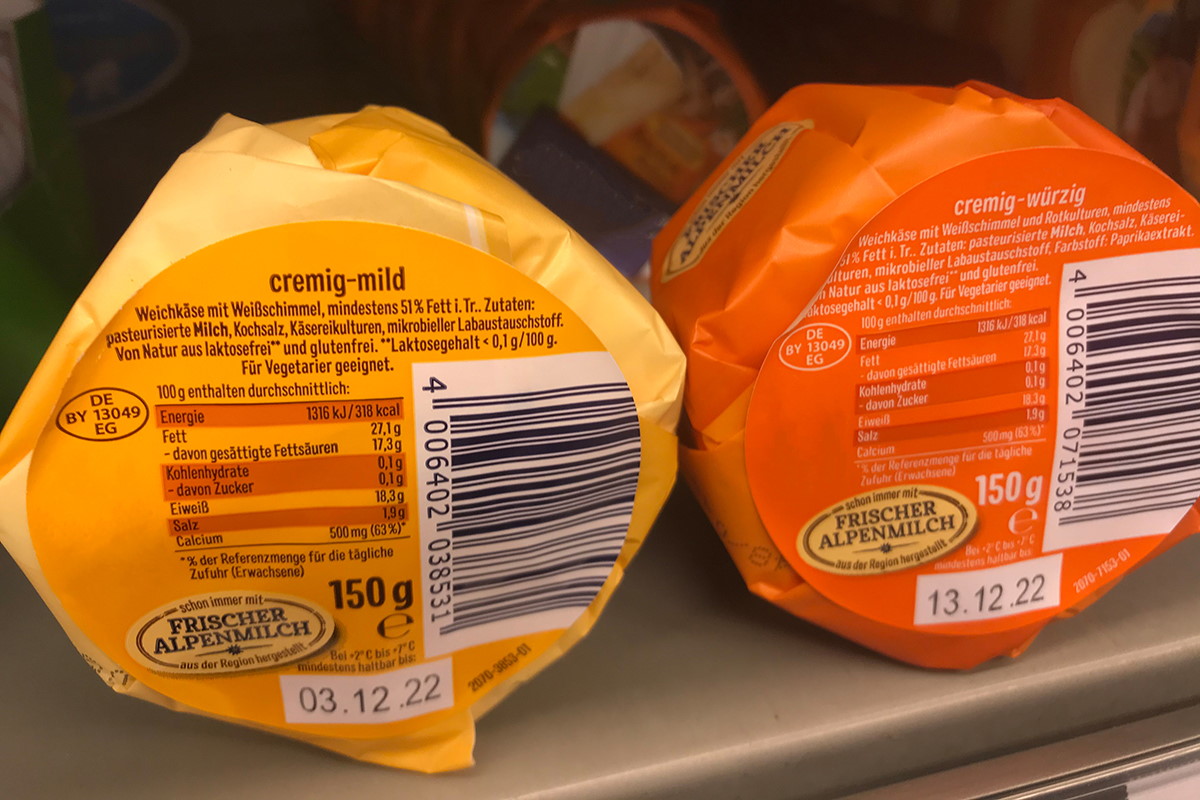 Lösungen Lebensmittel: Two-in-one Produkt- und Verschlussetikett, farbig vorbedruckt, nachträglich thermotransferbedruckt mit Inhalt, MHC, Barcode, auf Käseverpackung