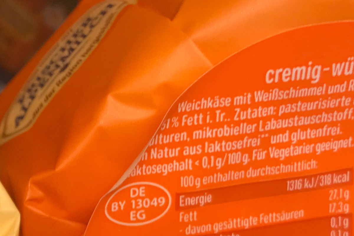 Lösungen Lebensmittel: Two-in-one Produkt- und Verschlussetikett, farbig vorbedruckt, nachträglich thermotransferbedruckt mit Inhalt, MHC, Barcode, auf Käseverpackung