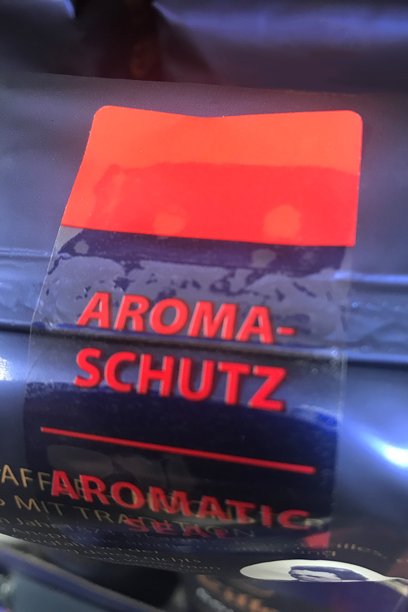 Verschlussetiketten: transparentes Wiederverschlussetikett, farbig bedruckt, auf Kaffeeverpackung aus Folie