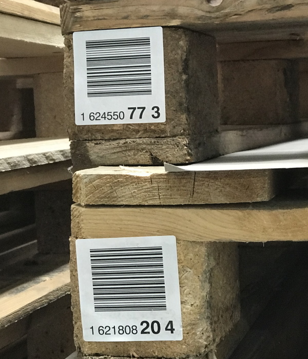 Versand- und Palettenetiketten: Palettenfuss Etiketten mit Barcode-Druck, auf rauen Holzpaletten (Palettensockel)