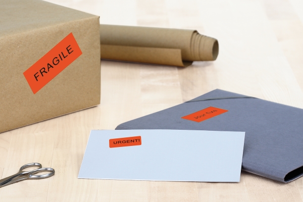 Farb- und Formsignale: rote Hinweisetiketten auf Karton und Post