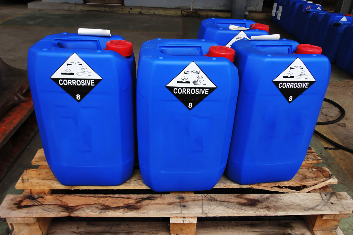 Gefahrstoff- und Gefahrgut-Etiketten: Gefahrgutetiketten auf blauen Kunststoffkanistern in der Chemiebranche