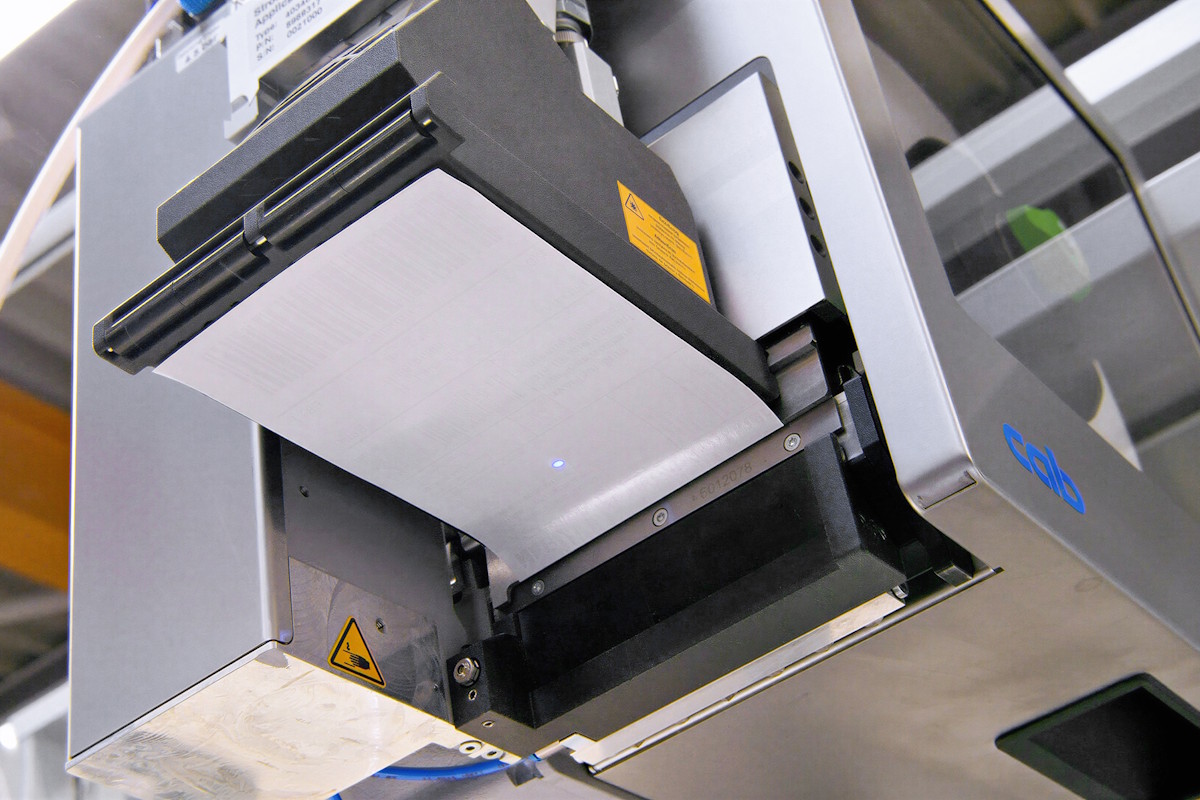 Linerless Etikett HERMA InNo-Liner in cab Print&Apply-System, bereit zum Spenden auf den Versandkarton