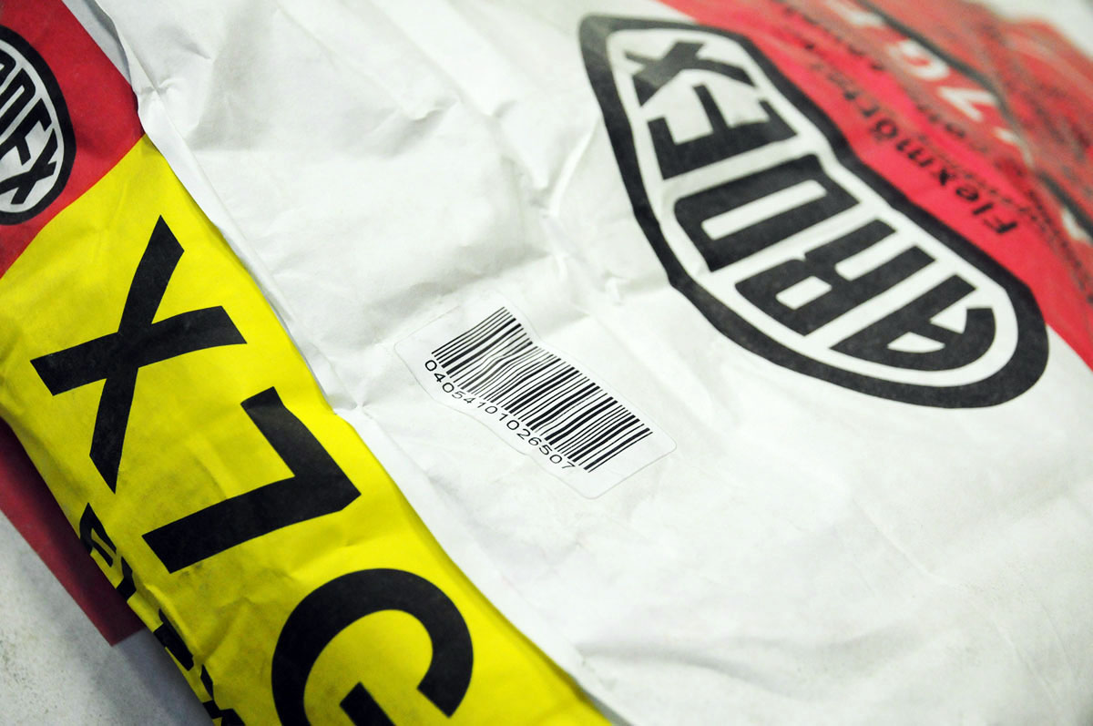 Produktkennzeichnung: Laseraktivierbares Etikett mit Barcode, auf staubigem Mörtelsack