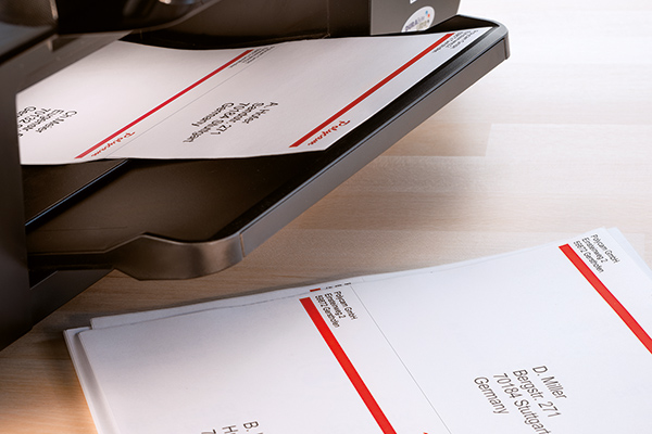 Bedruckter Etikettenbogen kommt aus dem Drucker, eingesetzt für Verarbeitungshinweise