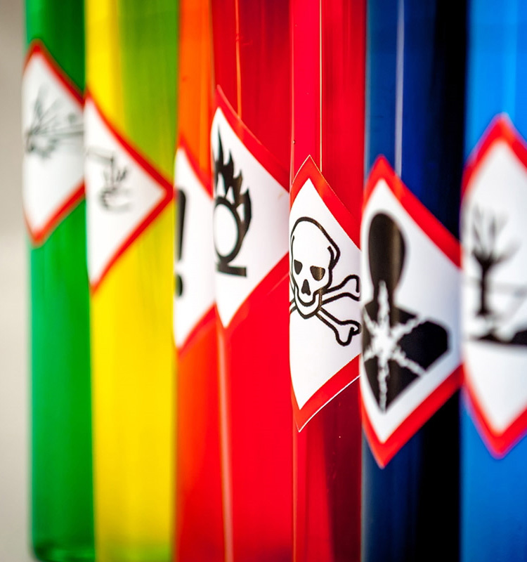Gefahrstoff- und Gefahrgut-Etiketten: Gefahrgutetiketten auf farbigen Behältern in der Chemiebranche