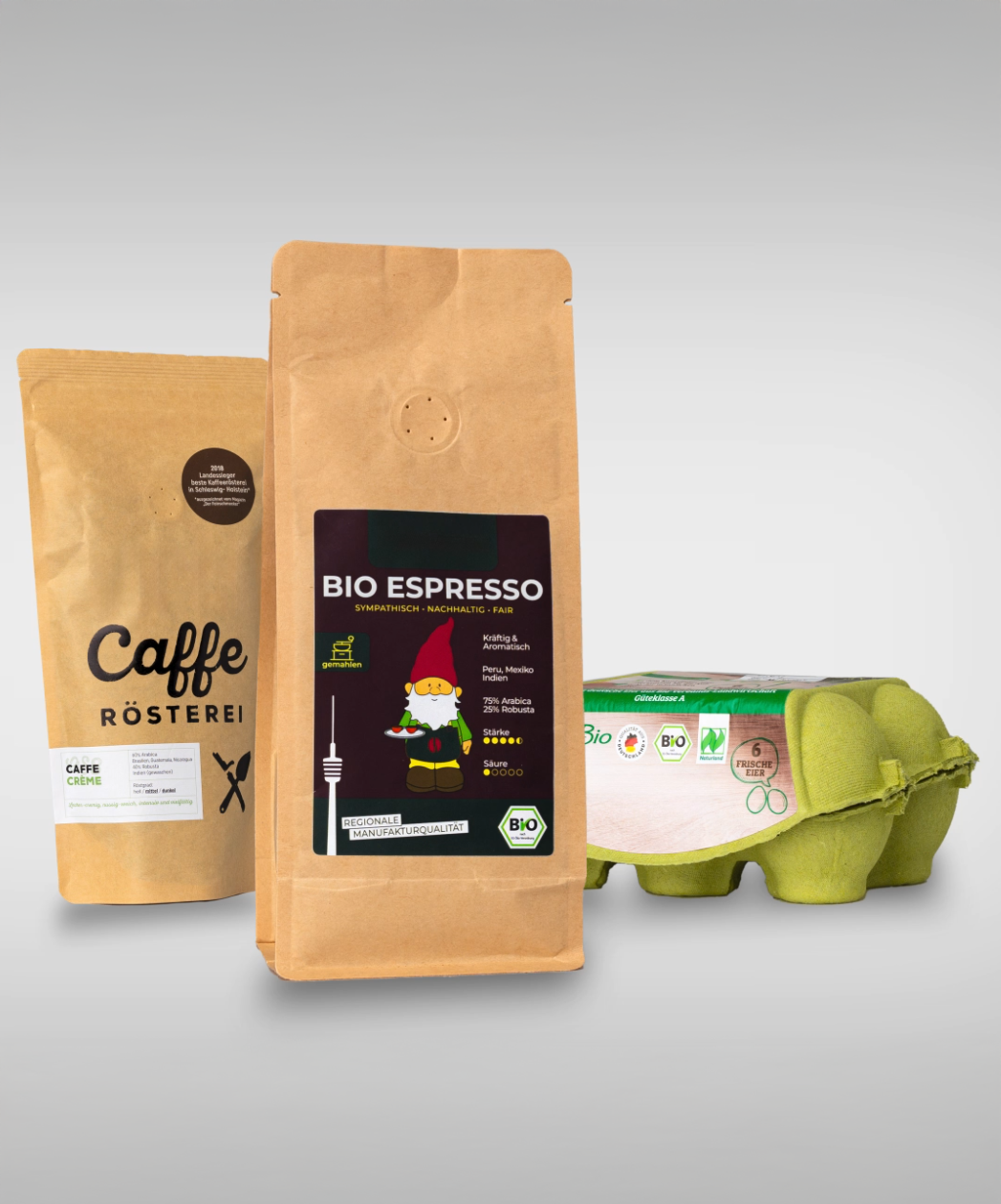 Zwei Kaffeetüten und eine Packung Bio-Eier. Eine Tüte enthält Bio-Espresso mit einem bunten Etikett.