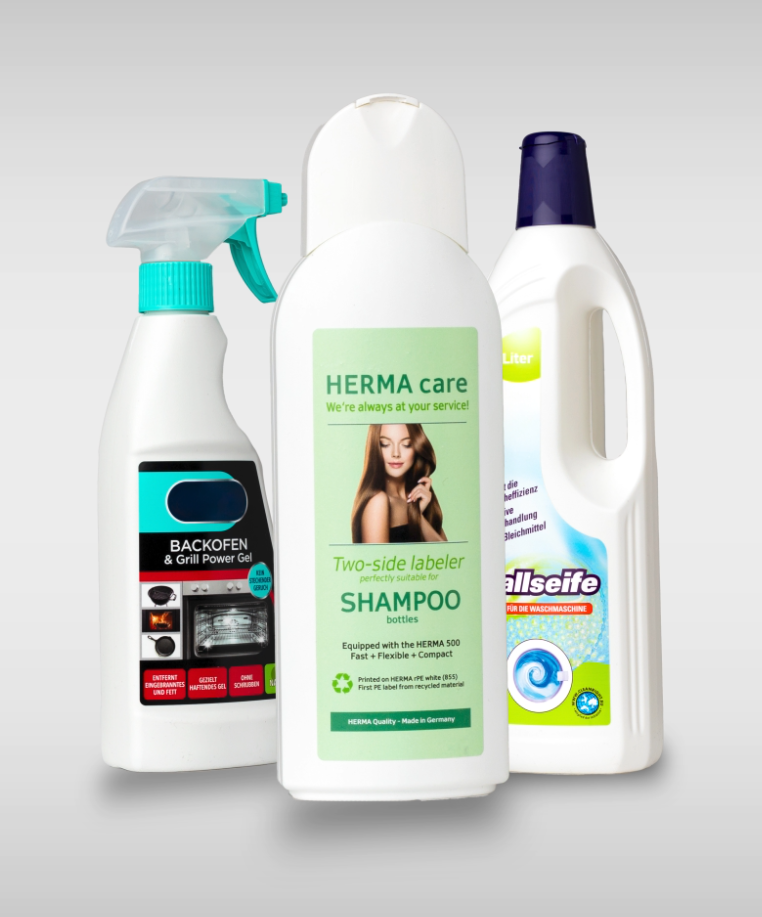 Drei Reinigungsprodukte: ein Spray für Backöfen, eine Shampoo-Flasche mit doppelter Etikettierung und ein Flaschenreiniger.