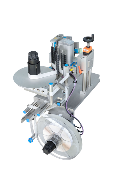 Automatische Etikettiermaschine mit einem runden Etikettierkopf und einer Spule für Etikettenmaterial.