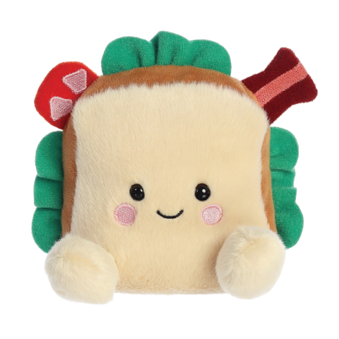 Kuscheliges Sandwich-Kissen mit lächelndem Gesicht, grünen Blättern und bunten Zutaten wie Speck und Pilzen.