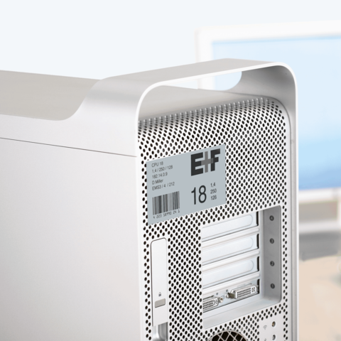 Silberner Computer-Tower mit perforierter Rückseite, ausgestattet mit mehreren Steckplätzen und technischen Spezifikationen auf einem Aufkleber.