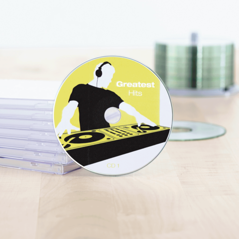 CD mit dem Titel "Greatest Hits" und einem DJ-Design, umgeben von transparenten CD-Hüllen.