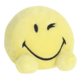 Gelbes, lächelndes Kissen in Form eines Smiley mit einem zwinkernden Auge und zwei kleinen, runden Füßen.