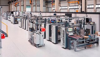 Eine moderne Produktionshalle mit mehreren Maschinen und Anlagen, die für die Fertigung und Montage von Komponenten eingerichtet sind.