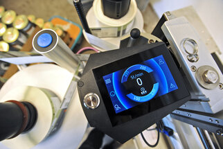 Bedienfeld eines Geräts mit digitaler Anzeige, die Drehzahl in U/min anzeigt. Gerätekomponenten sind sichtbar.