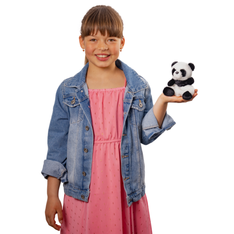 Ein Mädchen in einem rosa Kleid und einer Jeansjacke hält einen kleinen Plüschpanda in der Hand und lächelt.