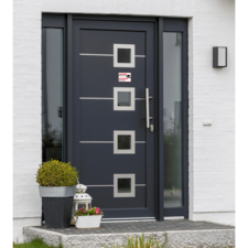 Moderne Eingangstür in Dunkelblau mit vier quadratischen Fenstern und einem silbernen Griff. Pflanze in einem Topf neben der Tür.