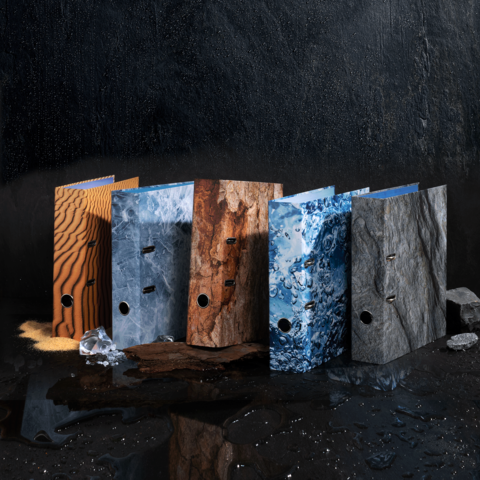 Farbenfrohe Ordner in verschiedenen Texturen stehen auf einer dunklen Oberfläche, darunter Holz-, Stein- und Wasserdesigns.