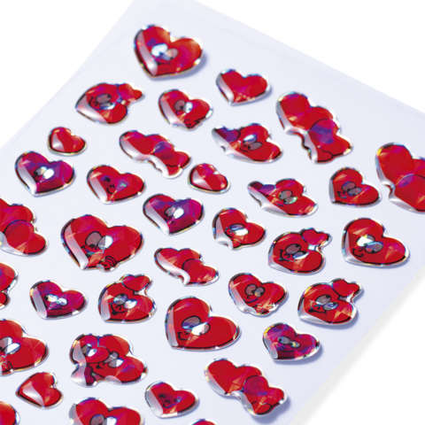Bunte Aufkleber in Herzform, überwiegend rot, mit verschiedenen Designs und Gesichtern, auf einem weißen Hintergrund angeordnet.