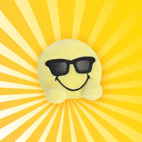 Gelbes Smiley-Kissen mit Sonnenbrille auf einem strahlend gelben Hintergrund.