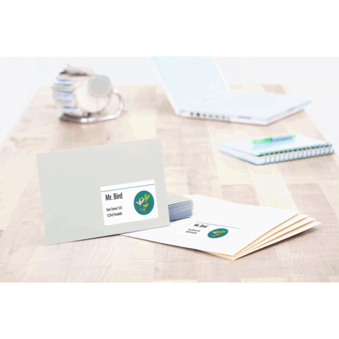 Ein Briefumschlag mit dem Namen "Mr. Bird" und einem Logo, daneben liegen weitere Umschläge und ein Stapel Visitenkarten auf einem Tisch.