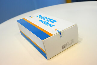 Verpackung mit der Aufschrift "TAMPER evident" in Blau und Orange, hergestellt von HERMA.