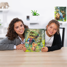 Eine Frau und ein Mädchen halten ein Buch mit Dinosaurierillustrationen auf einem Tisch. Im Hintergrund sind Pflanzen und Dekorationen sichtbar.