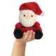 Eine Hand hält eine kleine, plüschige Weihnachtsmannfigur mit rotem Hut und Anzug.