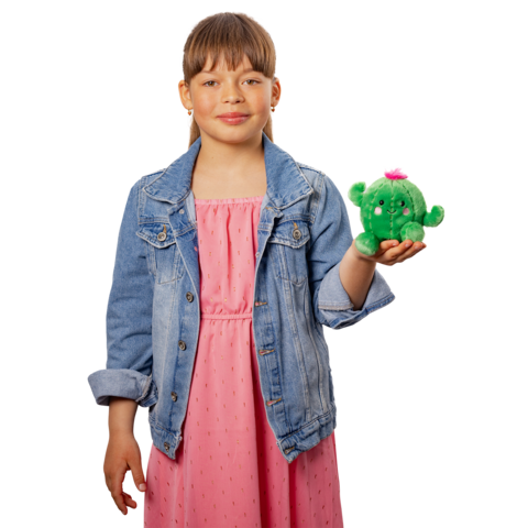 Ein Mädchen in einem rosa Kleid und einer Jeansjacke hält ein grünes Plüschspielzeug mit einer pinken Blume in der Hand.