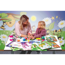 Eine Frau und ein Mädchen sitzen an einem Tisch, umgeben von Malutensilien und bunten Zeichnungen, und unterhalten sich freundlich.