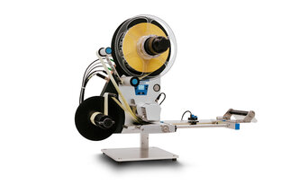 Eine Maschinenvorrichtung mit einer großen Spule, die gelbes Material aufwickelt, und einem Ausgabemechanismus auf einer stabilen Basis.