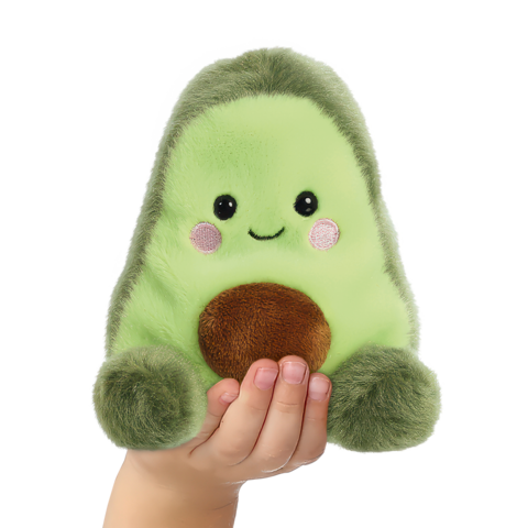 Ein handgehaltenes, grünes Plüschavocado mit einem lächelnden Gesicht und braunem Kern.