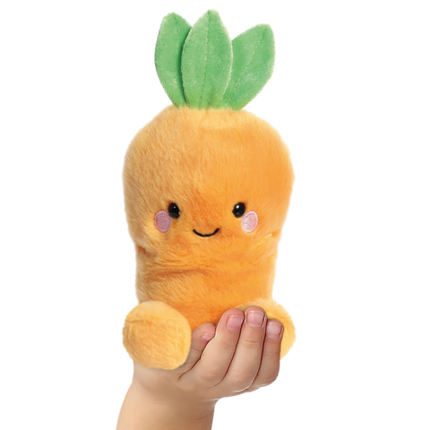 Ein orangefarbenes, plüschiges Spielzeug in Form einer Karotte mit grünen Blättern, gehalten von einer Hand.