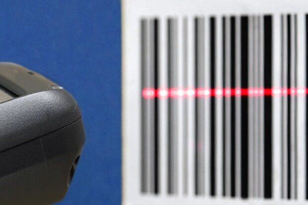 Hand mit Scanner beim Einscannen eines Barcode Etiketts, Querformat