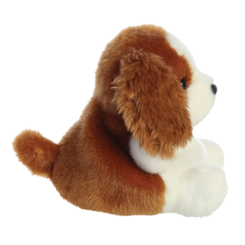 Plüschhund im Sitzen, mit braun-weißen Fell und einem runden Körper. Der Hund hat große, freundliche Augen und einen kleinen Schwanz.