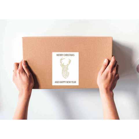 Braune Geschenkbox mit einem Etikett, das "Frohe Weihnachten und ein glückliches neues Jahr" sowie ein Rentiermotiv zeigt.