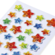 Bunte Glitzersterne in verschiedenen Farben auf einem weißen Hintergrund, angeordnet in einem regelmäßigen Muster.